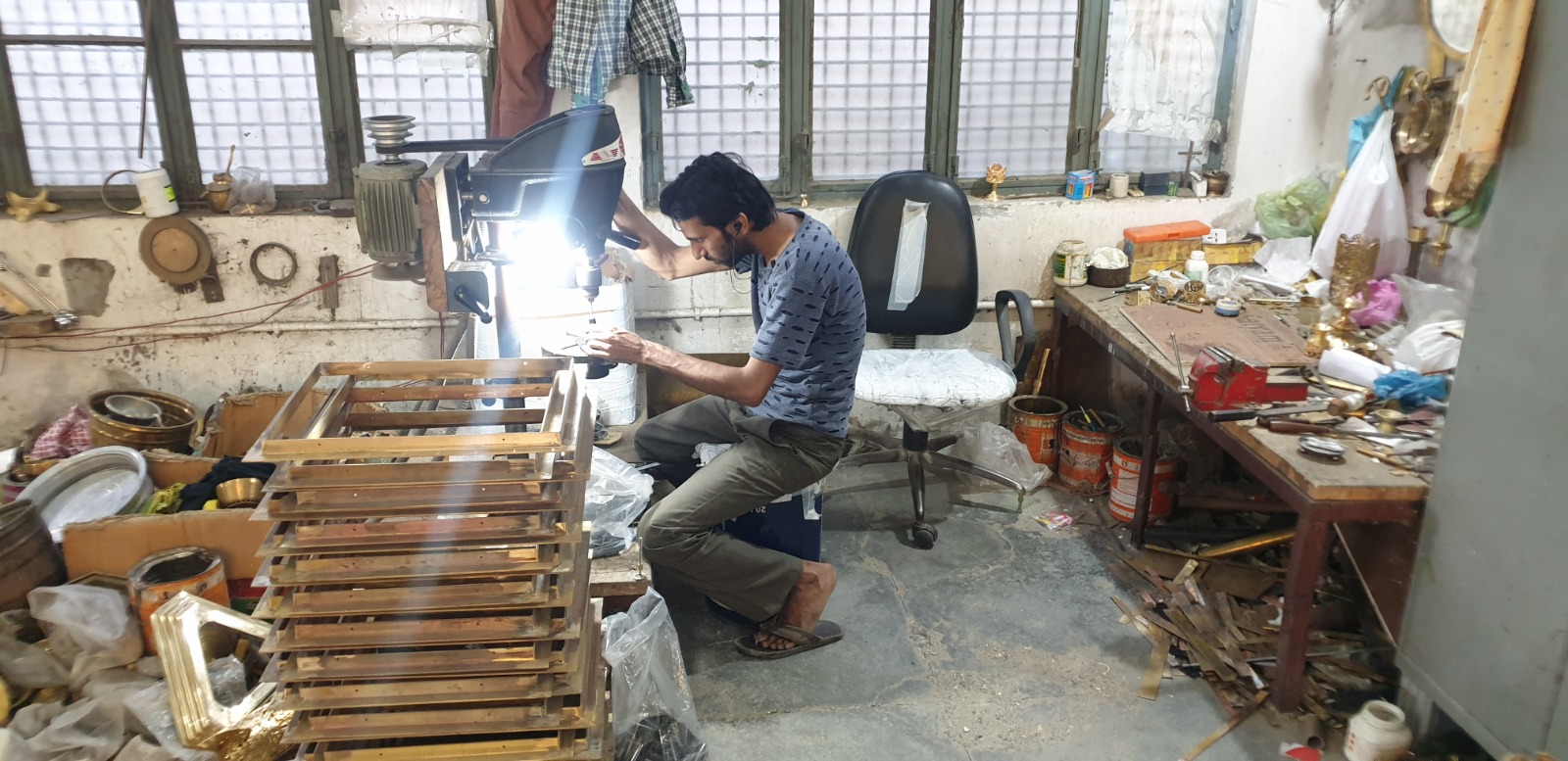 Craftsman at the drill press preparing brass components in the Moradabad workshop